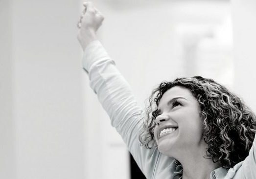 The secret to success - Woman celebrating with hands up